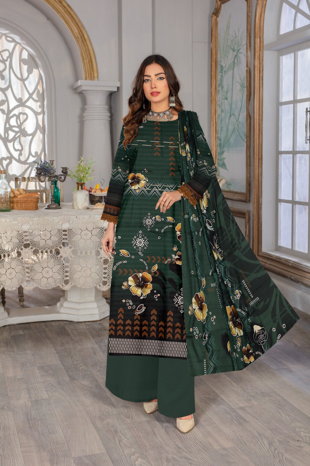 Woman in a green embroidered outfit standing in an elegant room with decorative elements.